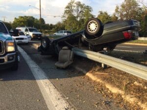 Overturned SUV against a guardrail beside the road