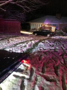 Crushed car loaded on a flatbed tow truck at night