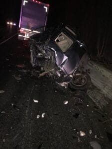 Wrecked car at a nighttime accident scene