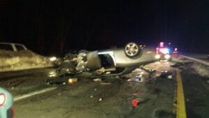 Car flipped onto its roof on a dark road after a crash